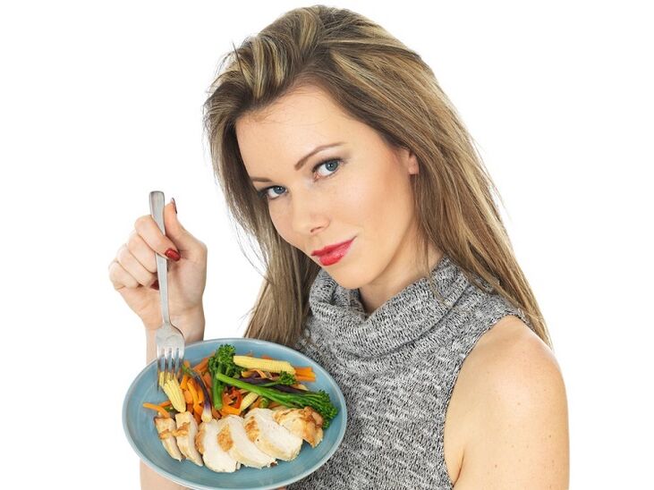 djevojka jede piletinu s povrćem za mršavljenje